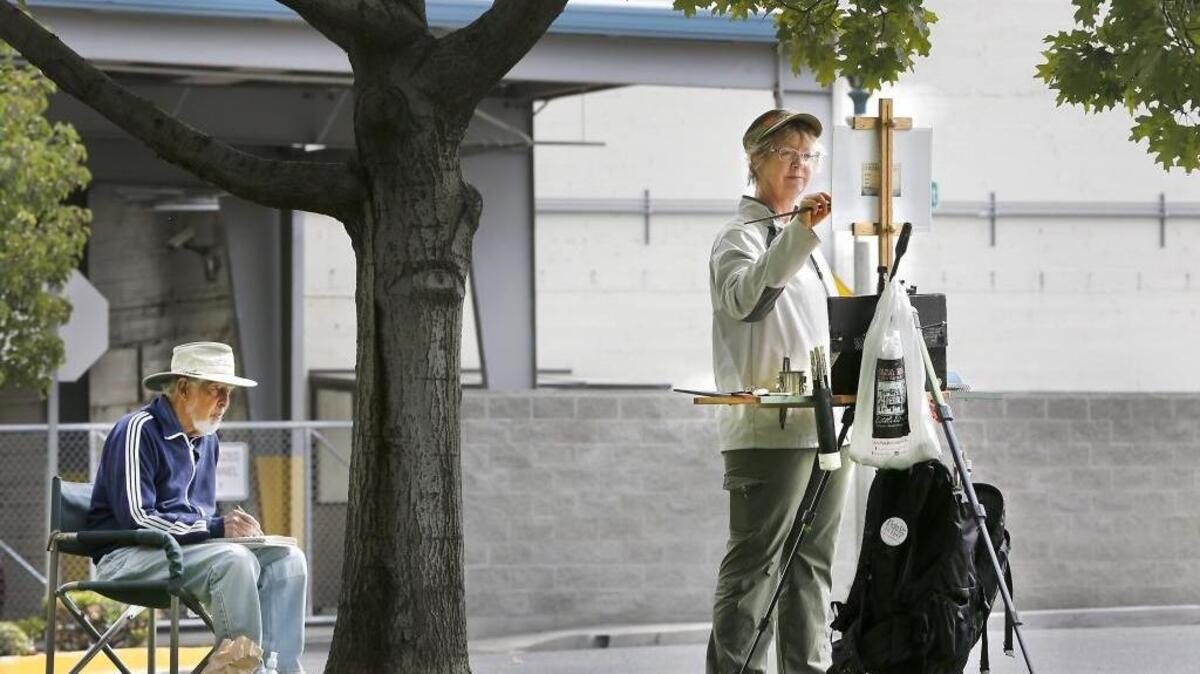 
Artists John Fabian, 81, of Richland and Laura Gable, 57, of Kennewick sketch and paint a scene Tuesday in on West Albany Street in downtown Kennewick. The two are part of an informally organized group of friends that meet a couple times each month to artistically capture outdoor scenes on their canvas and paper.
