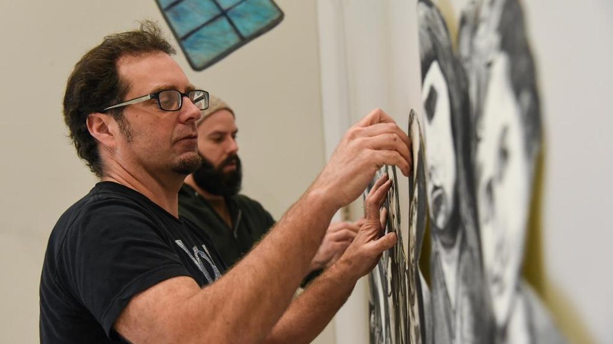 Artist Joe Batt, left, and Peter Christenson, a Washington State University Tri-Cities art professor, install Batt’s “In the Cloud” exhibition in The Art Center on the Richland campus. The show runs through Feb. 26.