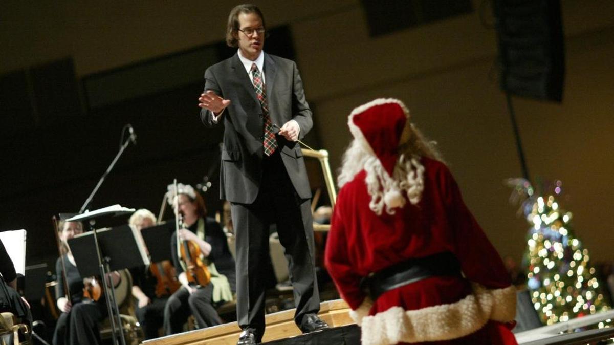 Nicholas Wallin, music director of Mid-Columbia Symphony, interacts with Santa Claus at a past symphony holiday concert.
