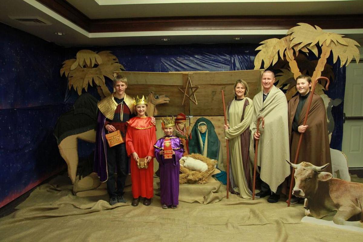 A family poses for a free photo at the Christmas Nativity Showcase at The Church of Jesus Christ of Latter-Day Saints in West Richland.