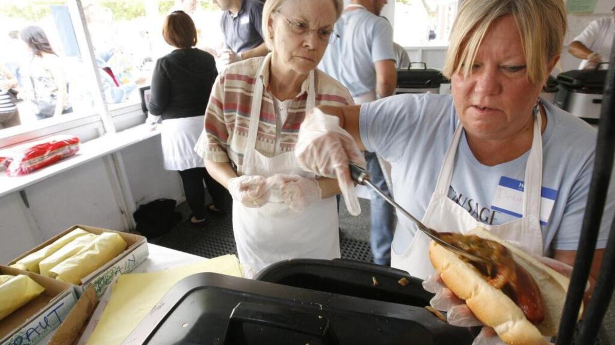 Volunteers serve up sausages during Christ the King’s annual Sausage Fest in Richland. (File photo)