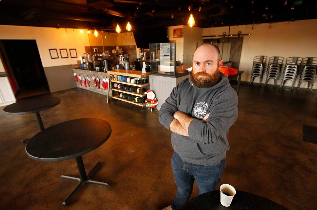 Kagen Cox, owner of Kagen Coffee & Crepes, recently stands inside his empty cafe at the Uptown Shopping Center in Richland,. He’s temporarily closed his business until the latest round of state mandated indoor dining restrictions are lifted in early January.