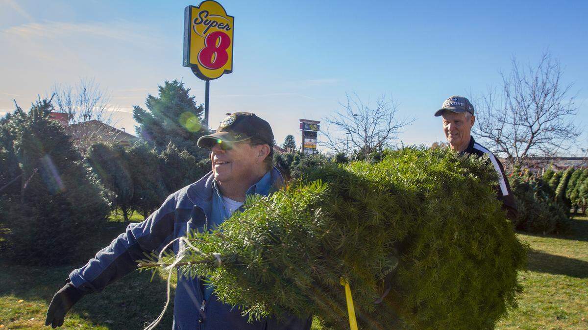 Rich Larson of Pasco, left, carries his Christmas tree with help of Rust Morse on Saturday at Lord of Life Lutheran Church in Kennewick. All of the profits from the church’s Christmas tree sale go toward Lord Of Life’s summer mission trip. Trees available are the noble, grand and Douglas firs. Prices vary.