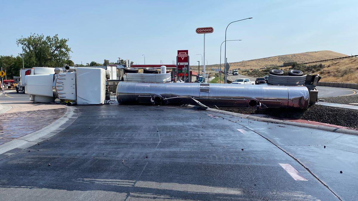 A semi tipped over and is dumping wine into the ditch at a Benton City roundabout near Interstate 82