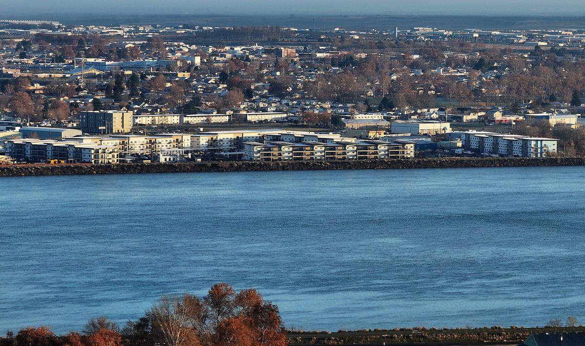 Columbia Riverwalk Apartment complex sprawls along the Pasco shoreline with downtown area in the background.