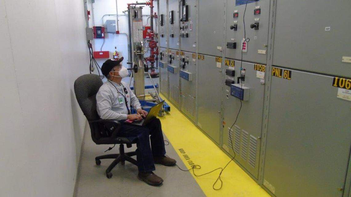 A Hanford worker wears a mask as he tests electrical breakers. Workers are now ordered to wear masks indoors, even if they are vaccinated against COVID-19.