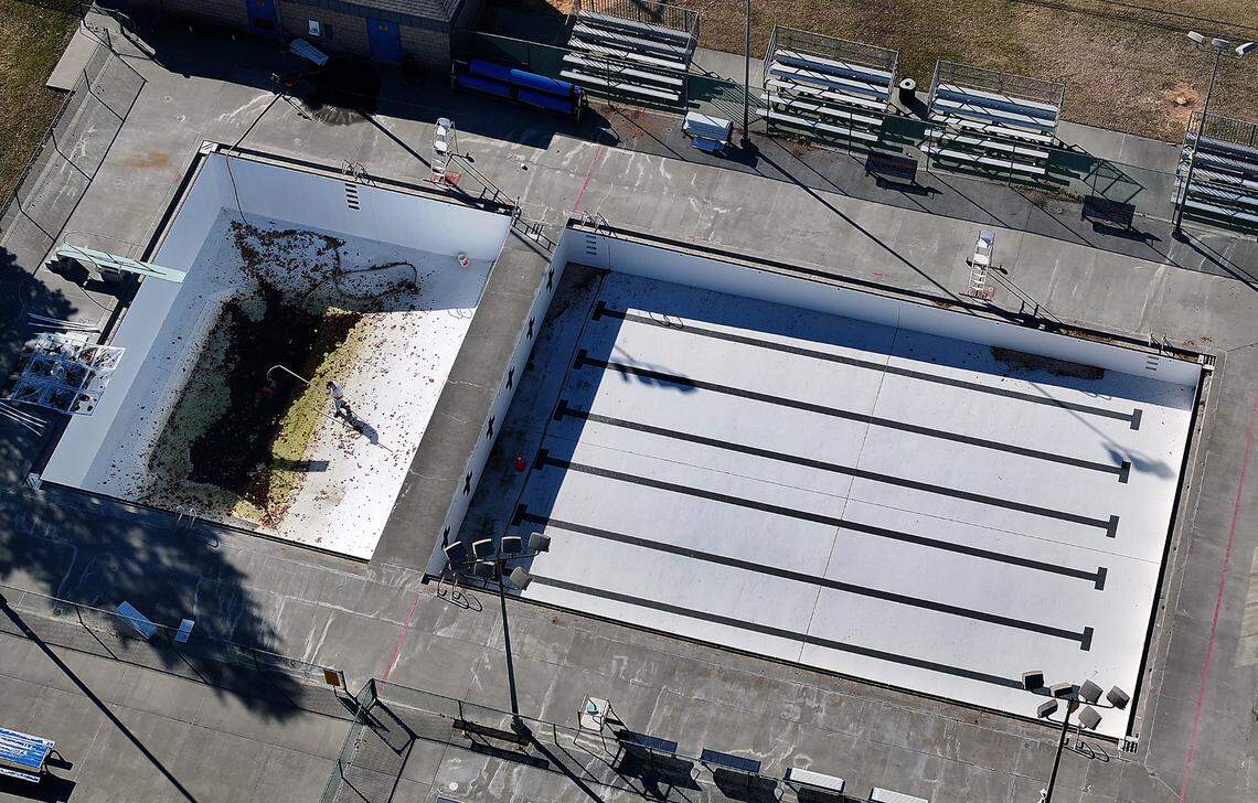 A worker cleans out windblown debris from the deep diving portion of the Kenneth Serier swimming pool in downtown Kennewick. “The pool is crumbling. It’s falling apart,” said one swim coach.