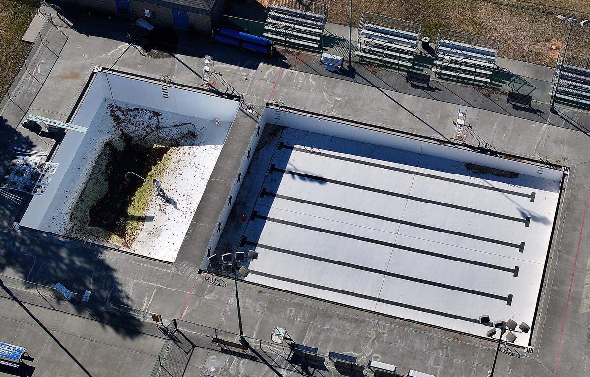 A worker cleans out windblown debris from the deep portion of the Kenneth E. Serier swimming pool in downtown Kennewick. Taken Feb. 26, 2025.