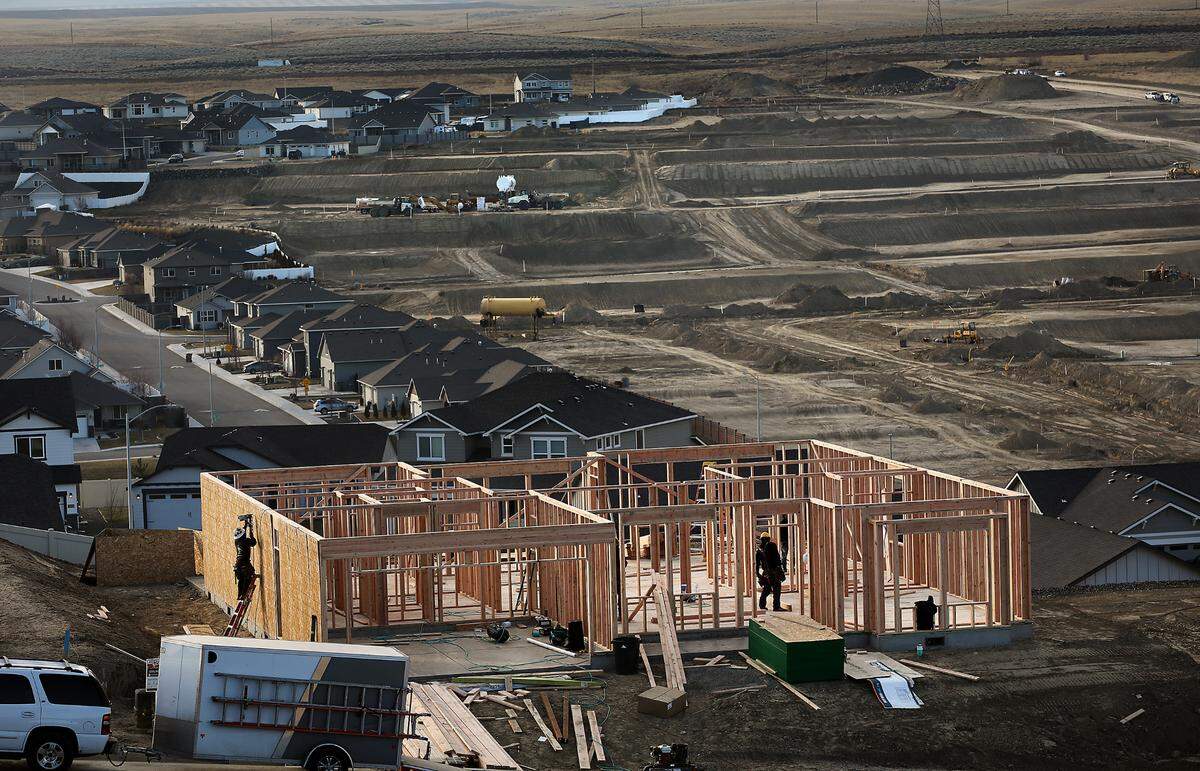 Construction workers frame a new house in the Sherman Heights housing development as heavy equipment works on phases 7-9 of the Apple Valley housing development off the Bob Olson Parkway in south Kennewick. The new Apple Valley development consists of 125 lots.