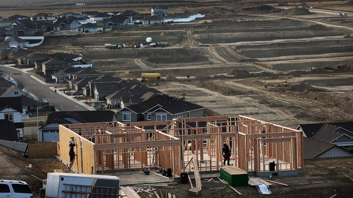Construction workers frame a new house in the Sherman Heights housing development as heavy equipment works at the Apple Valley housing development off the Bob Olson Parkway in south Kennewick.