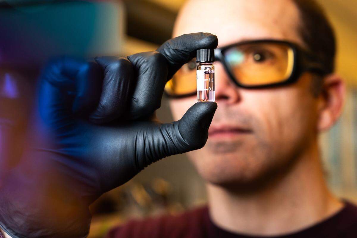 PNNL chemical engineer Josh Elmore loads samples into a scientific instrument to measure how well a specific bacteria can convert sugars into an industrial chemical.