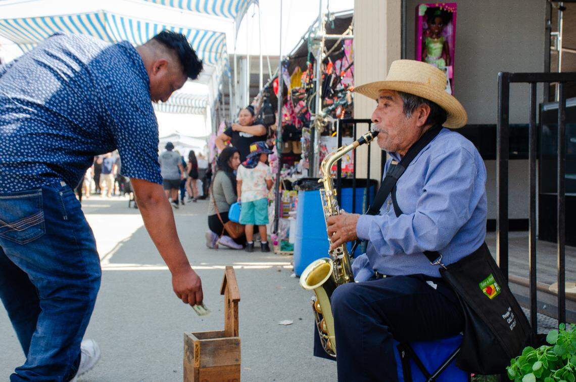 A shopper tips a saxophone player at the Pasco Flea Market. The seasonal market is open on weekends from March 1 to Nov. 1.