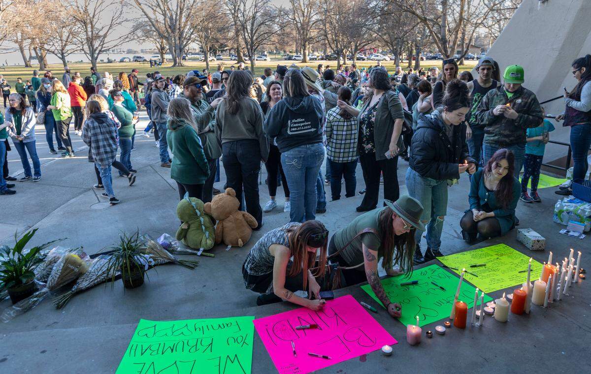 After a brief ceremony celebrating Justin Krumbah’s life, people took turns writing messages on posters and lighting candles in remembrance of the Instacart worker who was shot Monday inside Fred Meyer.