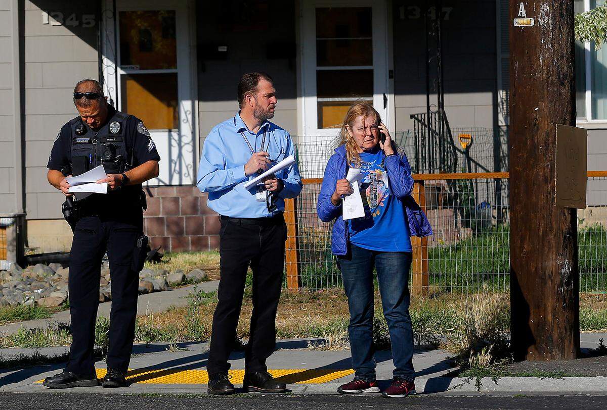 Joe Schiessl, Richland deputy city manager, stands with Linda Alexander, the owner of the burned out house, as demolition crews prepare to demolish the gutted structure.