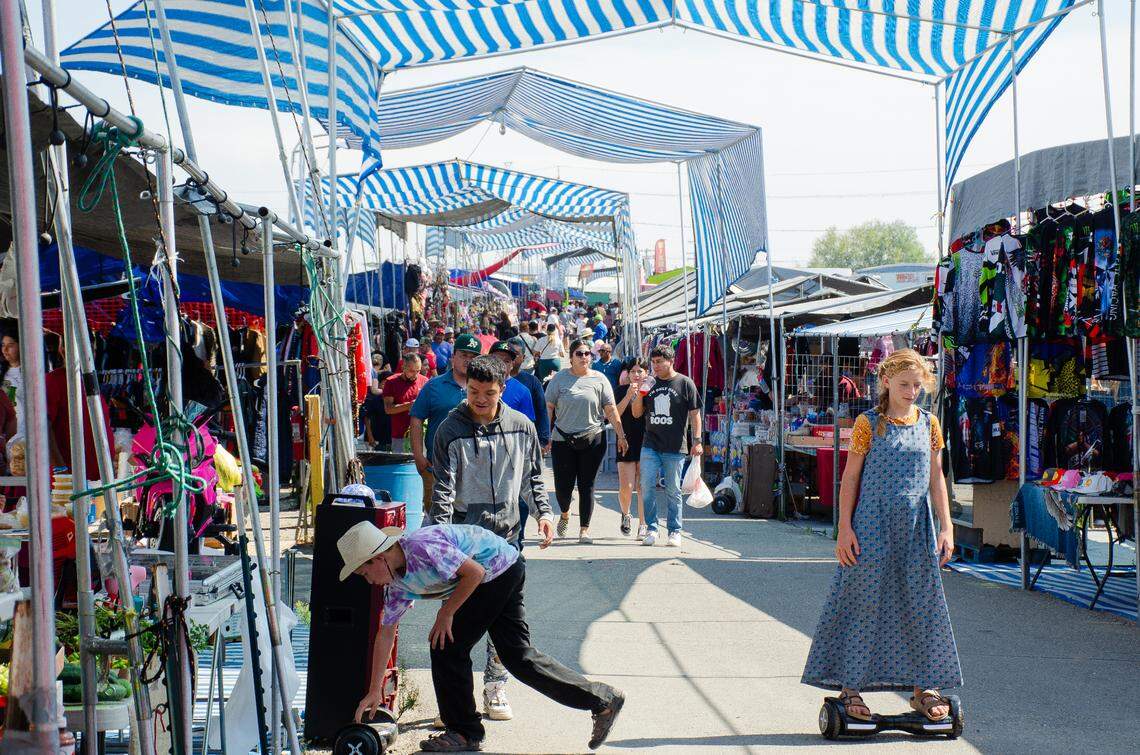 Kids ride on self-balancing electric scooters as shoppers in the background peruse past vendors Sunday, Aug. 27, at the Pasco Flea Market, located at 3620 E. Lewis Place.