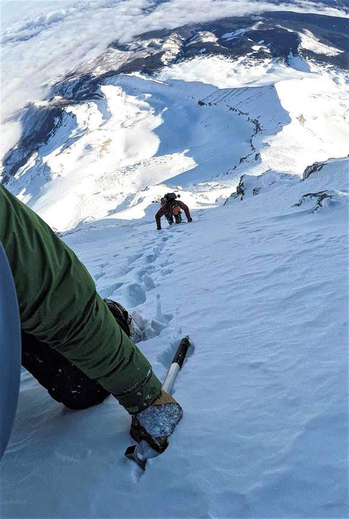 Dustin Wintczak turns his head to snap a GoPro photo of Jason Fidorra climbing up the ridge behind him.