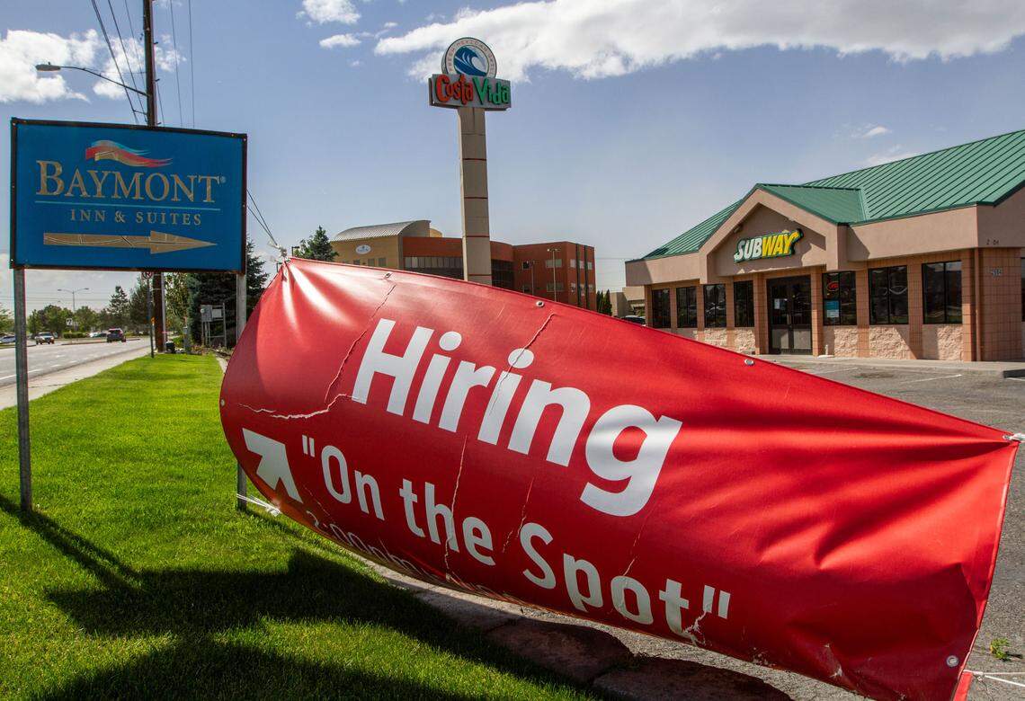 A “hiring on the spot” sign flaps in the wind outside of Subway in Kennewick as restaurants and hotels struggle to hire enough employees to be fully staffed.