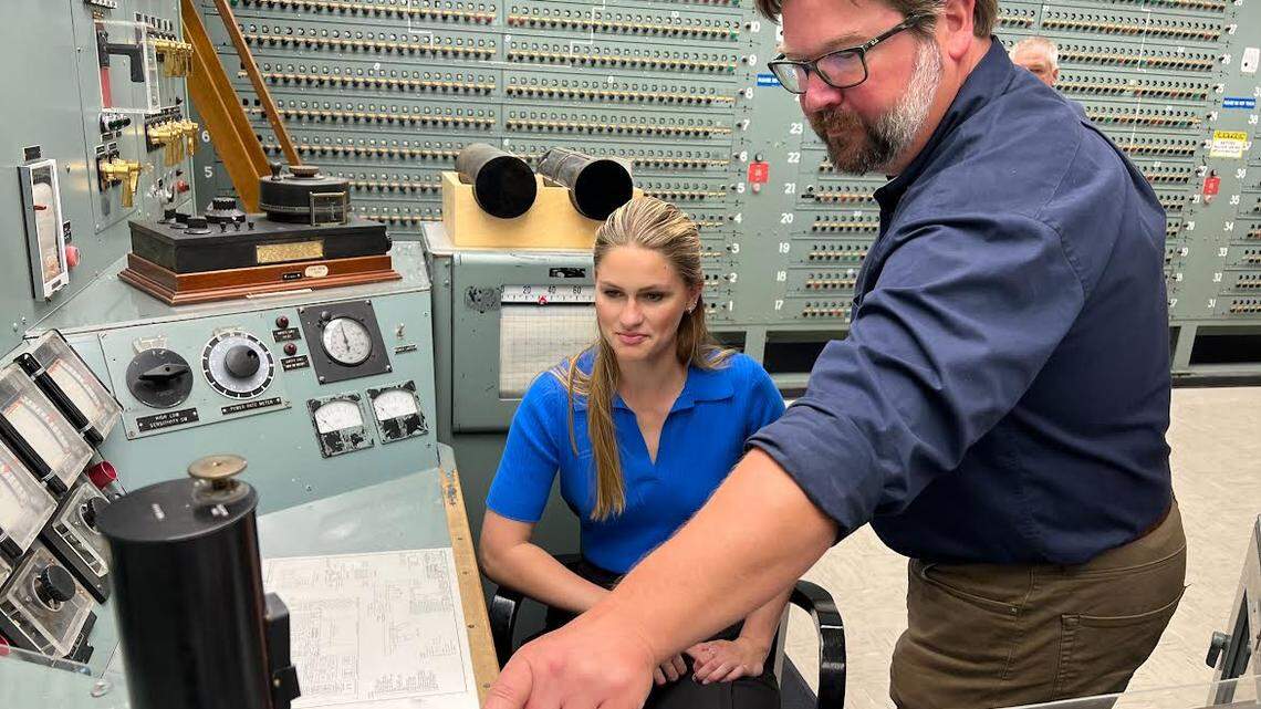 Miss America 2023 Grace Stanke sits at the control panel of historic B Reactor at Hanford as she is briefed by Patrick Jaynes, operations manager at the Manhattan Project National Historical Park.