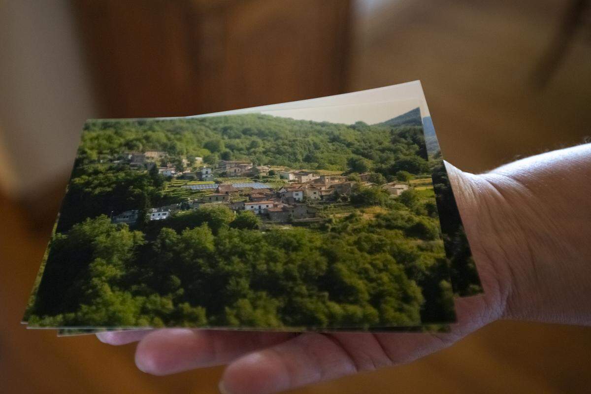 Manuel Pardini holds a photo of a small Italian town called Viviana, Italy, where his ancestors are from.