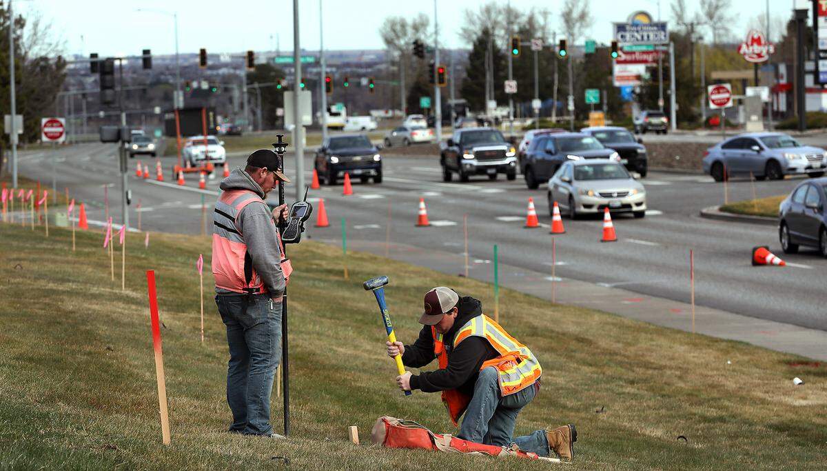 Stratton Surveying & Mapping employees Adam Glidewell, left, and Kevin Vaughn, place markers for construction crews to follow during a $1.6 million intersection improvement project.