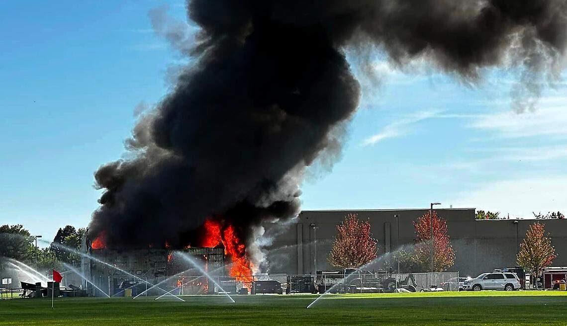 Smoke billows from an equipment shed Sunday afternoon at Hanford High School after the building, that originally burned early Saturday morning, reignited.
