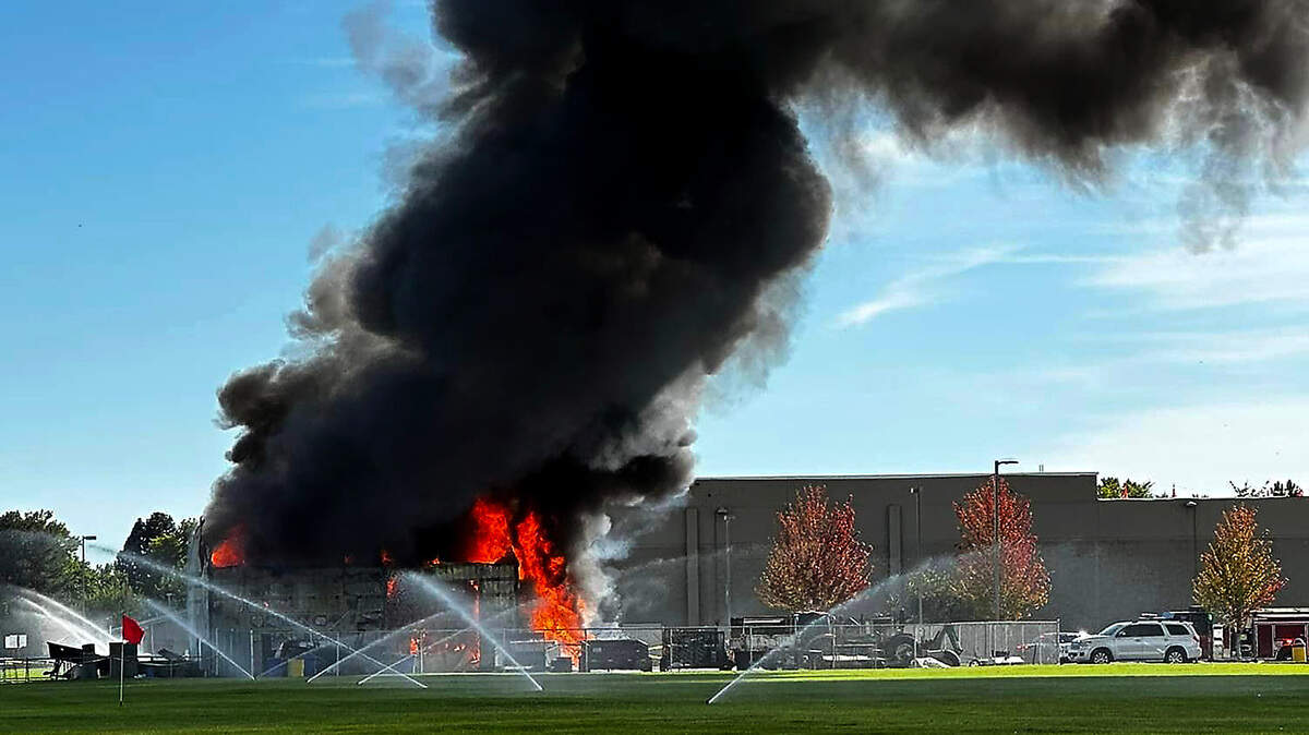 Smoke billows from an equipment shed Sunday afternoon at Hanford High School after the building, that originally burned early Saturday morning, reignited.