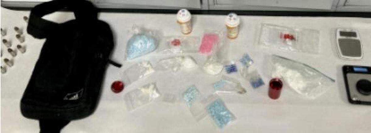 Richland police seized drugs carried in a fanny pack of a man accused of using a gun to threaten customers at a Richland Uptown Shopping Center bar early Sunday morning.