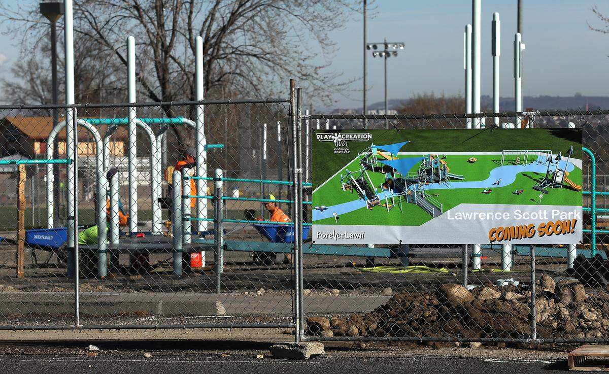 A pile of rocks and dirt, from holes drilled and dug out for equipment mounting posts, sits on the ground just inside the temporary construction fencing surrounding the installation project for new playground equipment at Lawrence Scott Park in west Kennewick.