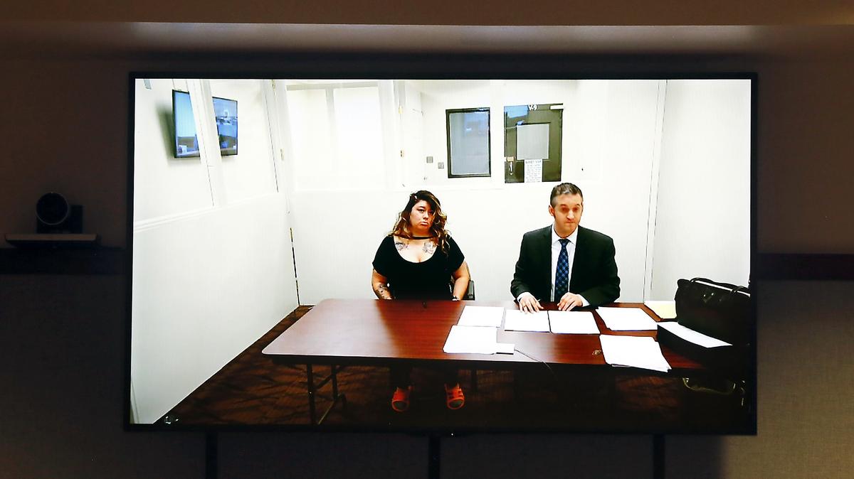 Suspect Patty Sitlai Vasquez-Lopez appears on a closed-circuit television screen Monday with provisional defense attorney Michael Quillen in Franklin County Superior Court.