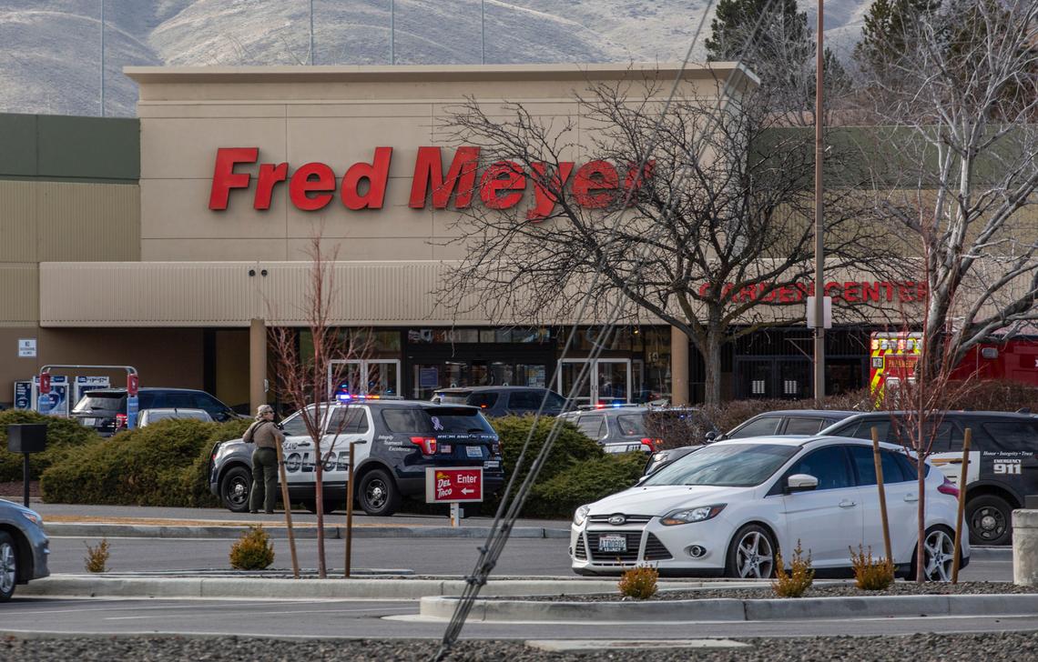 Law enforcement officers gather in the parking lot after one person was killed and at least one other wounded in a shooting inside the Fred Meyer store on Wellsian Way in Richland, Wash., on Monday morning. Police are searching for a suspect.