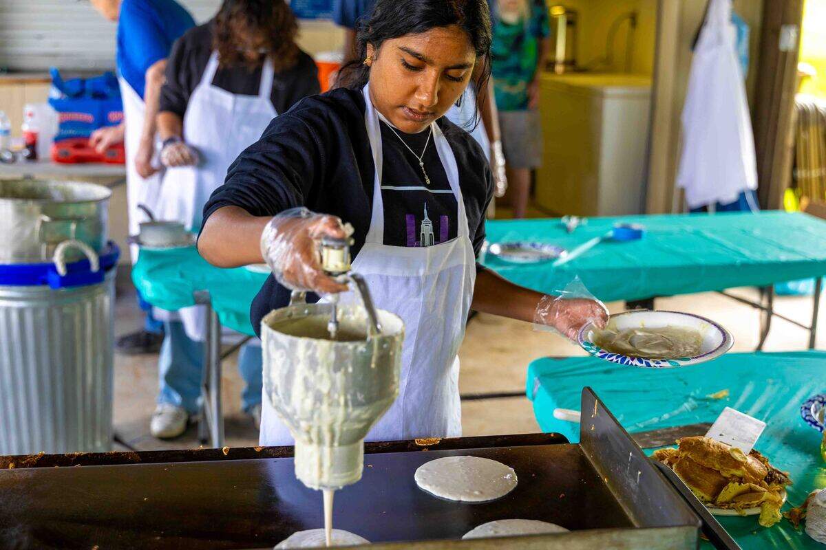 A local high school student volunteers at the Richland Kiwanis Pancake Breakfast on Saturday at Jefferson Park during Cool Desert Nights in Richland. The annual fundraiser was one of several community activities held as part of the weekend celebration.