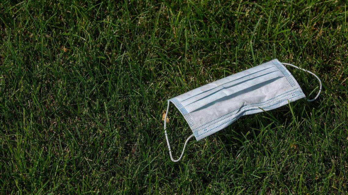 A discarded mask lays in the grass.