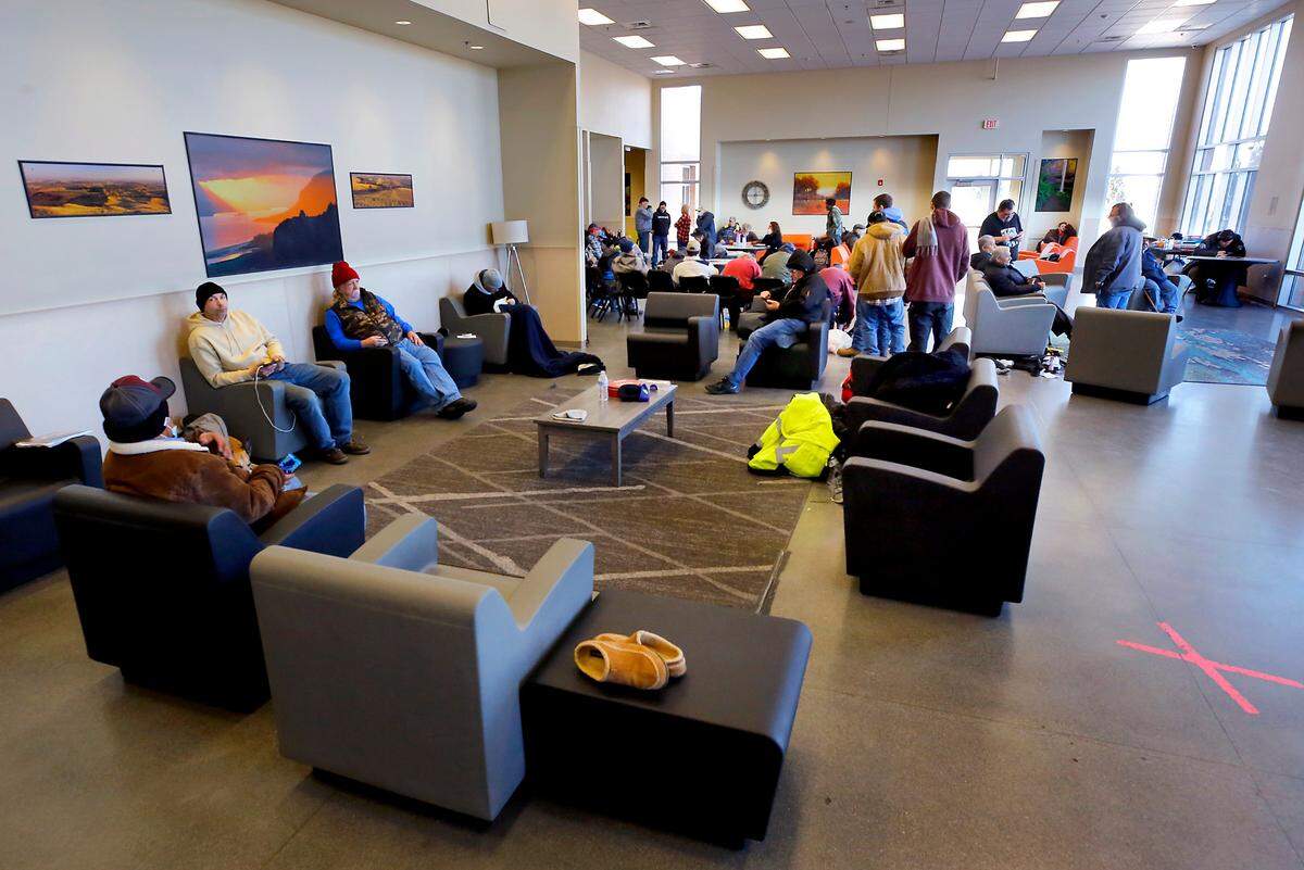 Homeless men seeking relief from the frigid outdoor temperatures gather in the day room at the Tri-City Union Gospel Mission on a recent winter day.