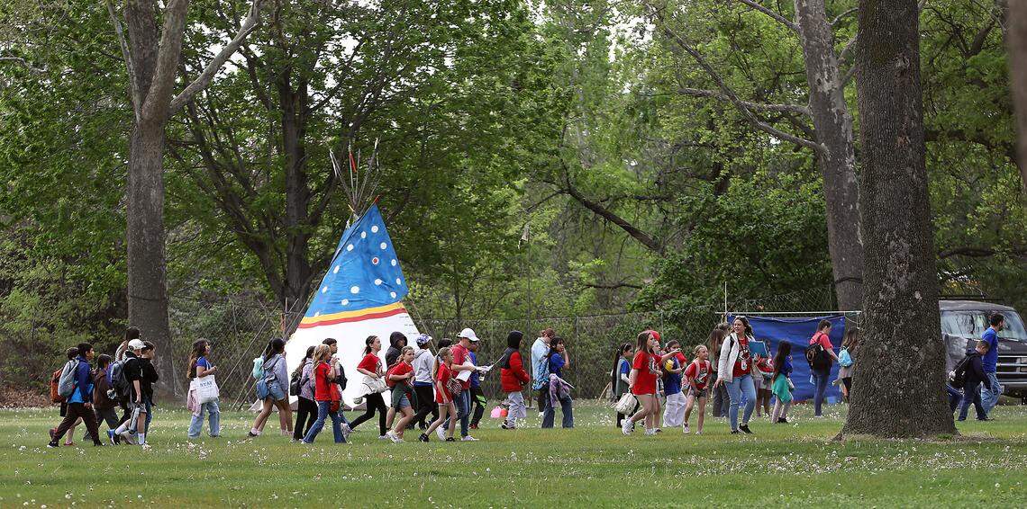 Elementary students, teacher and parent chaperones walk to the activities area after releasing the salmon fry they raised in their classroom through the Salmon in the Classroom program Tuesday morning into the Columbia River at the east boat launch in Kennewick's Columbia Park.