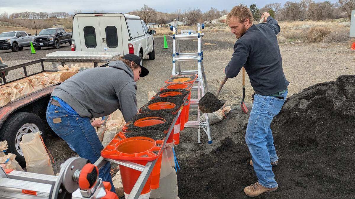 Hamilton Sivula, right, fills a sandbag at the Hamilton Road fire station in West Richland.