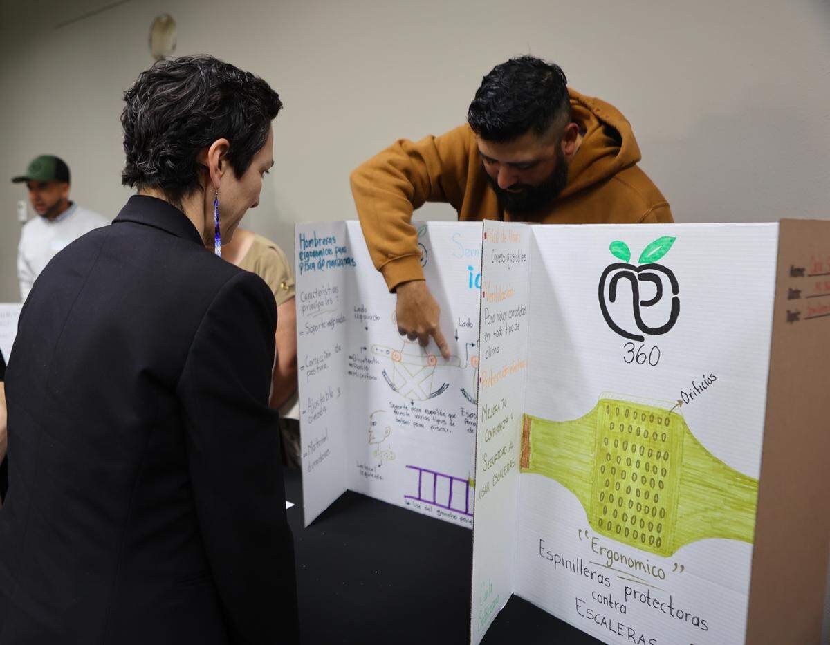 A farmworker explains an idea to Sen. Rebecca Saldaña during the Semillero de Ideas awards ceremony in Pasco. Saldaña’s father is a Mexican immigrant and former farmworker.