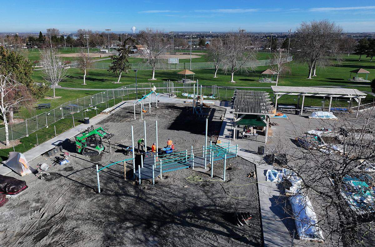 Workers install new playground equipment at Lawrence Scott Park in west Kennewick.