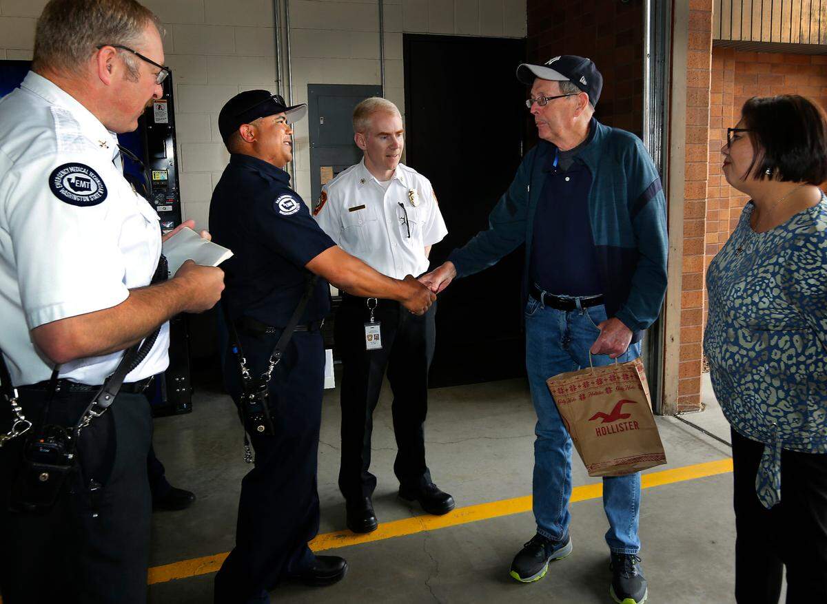Heart attack survivor Bill Granfield shakes hands with Kennewick Fire paramedic Earl Anema during his recent visit to thank first responders for reviving him after he collapsed on April 21 while jogging on 19th Avenue near Garfield Street.
