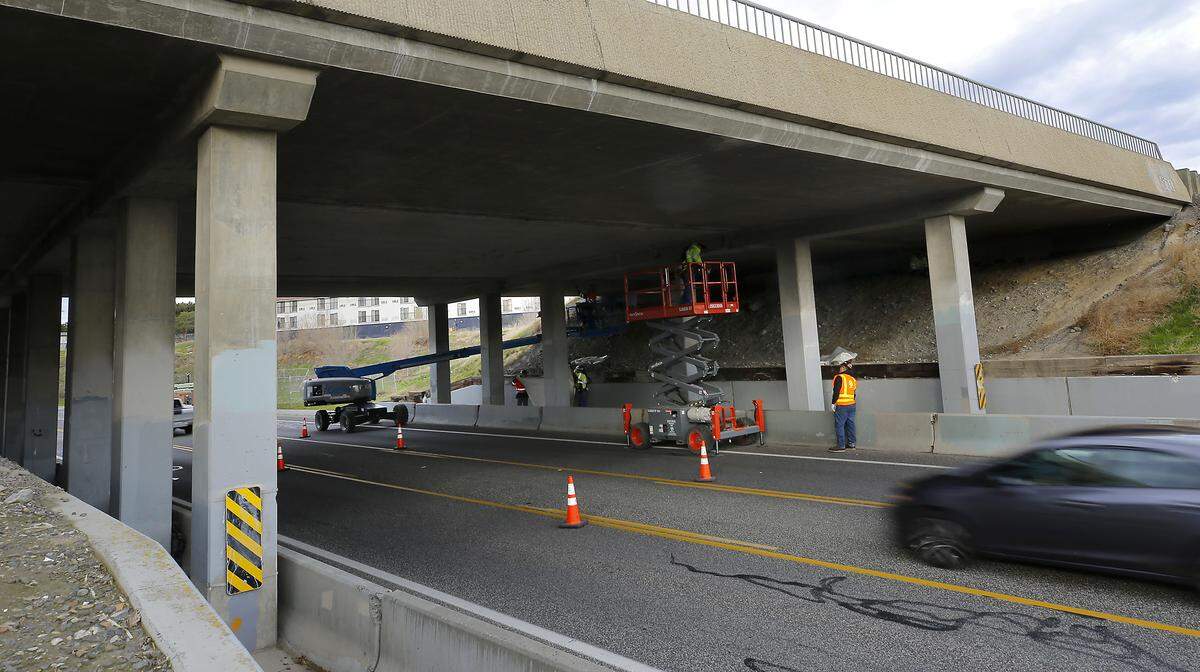 Washington Department of Transportation repair crews work Monday morning underneath the West Fourth Avenue overpass bridge which carries traffic on Highway 395 in Kennewick.