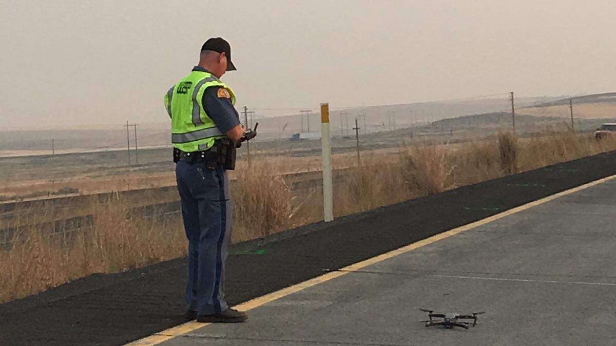 A Washington State Patrol trooper uses a drone to map the scene of Thursday morning’s fatal crash on Highway 395.