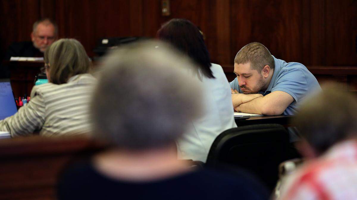 Joshua D. Davis, the Richland man charged with stabbing a Pasco school bus driver in September 2021, rests his chin on his folded arms during a hearing Monday in Pasco.