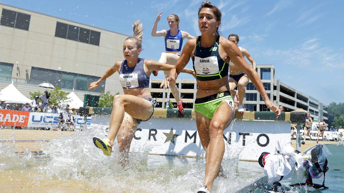Marisa Howard, left, runs through the water in a 2017 women’s 3000-meter steeplechase at the U.S. Track and Field Championships in California.