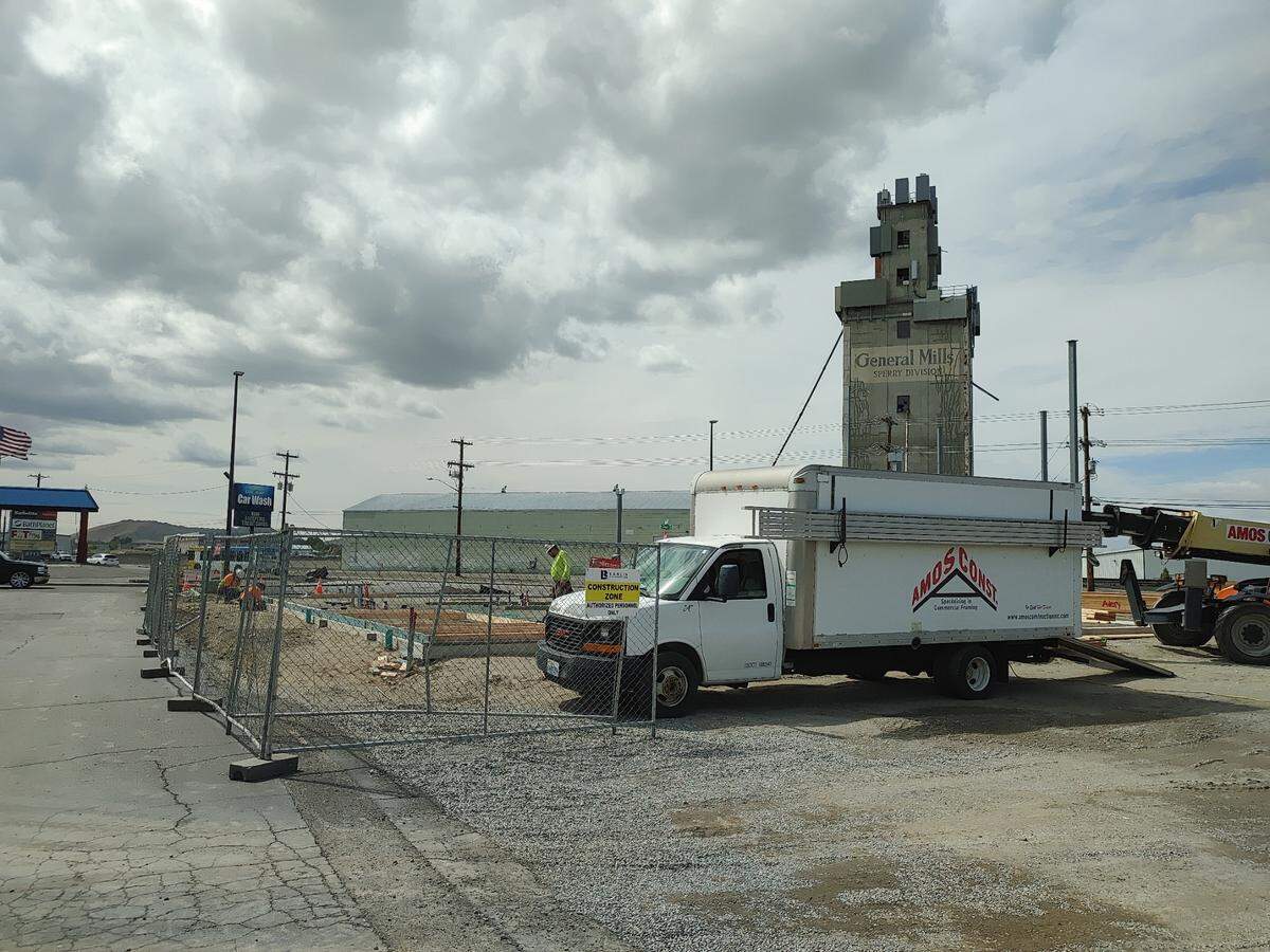 A crew works on the foundation for a new 4,536-square-foot office building at 6539 W. Clearwater Ave. The historic Centennial Mills elevator looms in the background in western Kennewick.