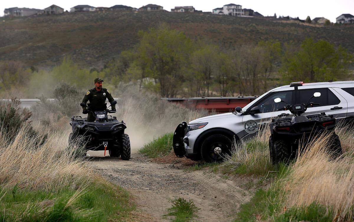 A Benton County Sheriff’s deputy uses a four-wheel ATV to investigate the scene on the BNSF tracks just off East Badger Road near 823 PR SE where a woman’s body was discovered by a train conductor.