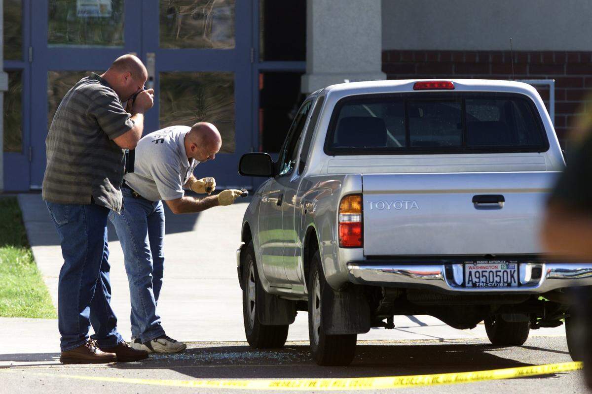Benton County detectives Doug Stanley, left, and Bob Brockman collect and document evidence in September, 2004 from Bob Mars’s truck outside the school where his body discovered.
