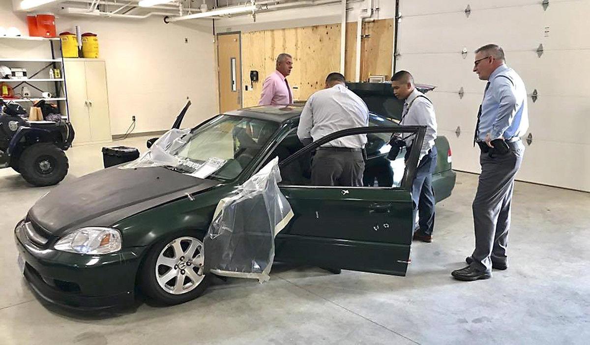 Pasco police Detective Sgt. Jamie Raebel and Detectives Jesse Romero, Jed Abastillas and Bill Wright search the victim’s Honda following a drive-by shooting in late October 2018.