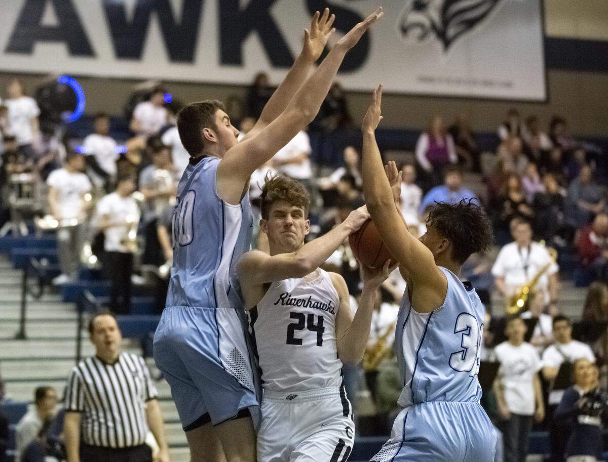 Central Valley’s Gavin Gilstrap (50), left, and Noah Sanders (30) attempt to block Matthew Kroner (24) of Chiawana, during the District 8 4A playoff game at Chiawana High School in Pasco on Monday. Chiawana defeated Central Valley 88-74.