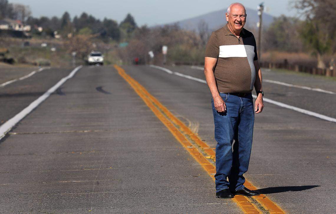 Local amateur historian Bill Glenn stands on a section of the century-old concrete highway near the golf course in Columbia Park in Kennewick.