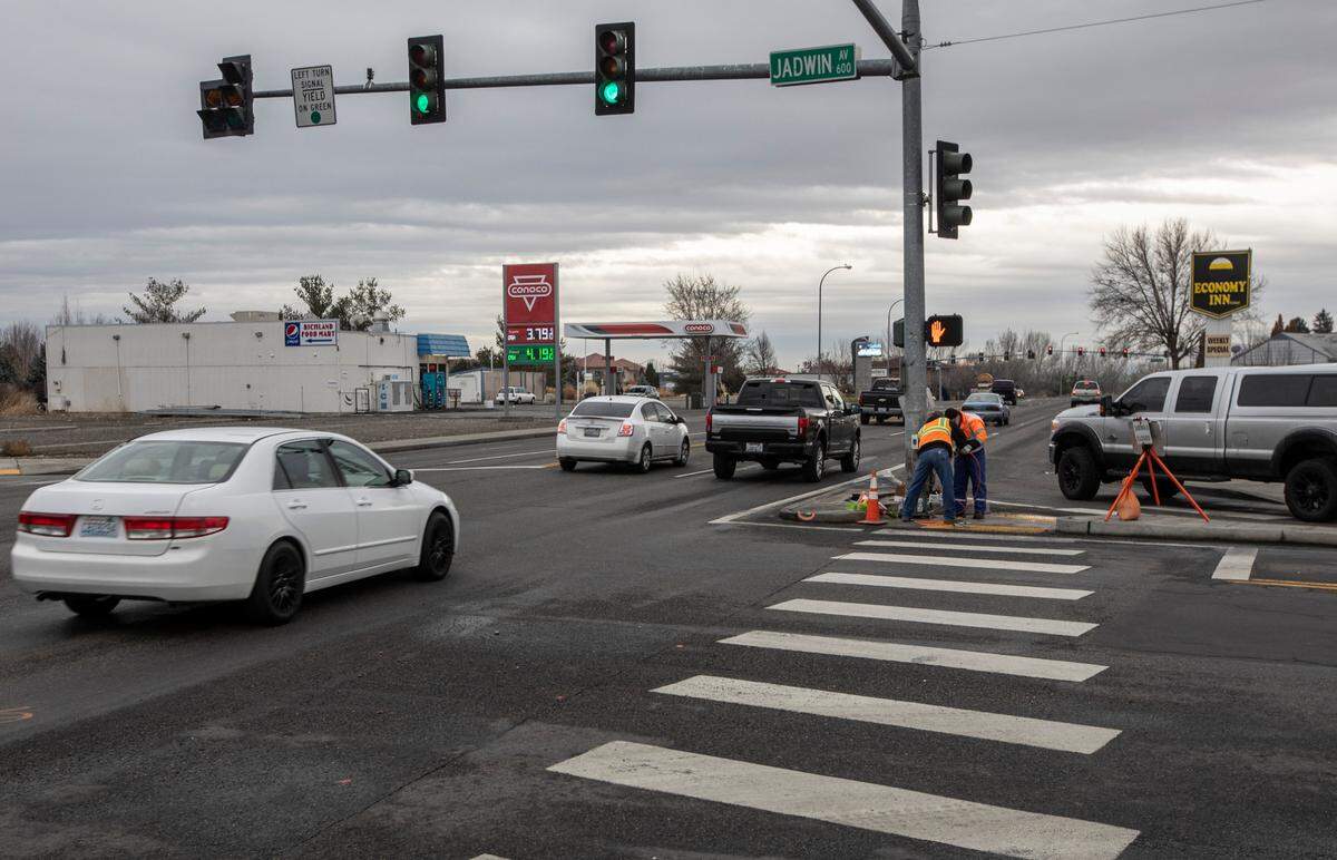 Richland utilities workers make repairs in February 2022 to a signal pole at the intersection of George Washington Way and Jadwin Avenue after a crash killed three passengers.