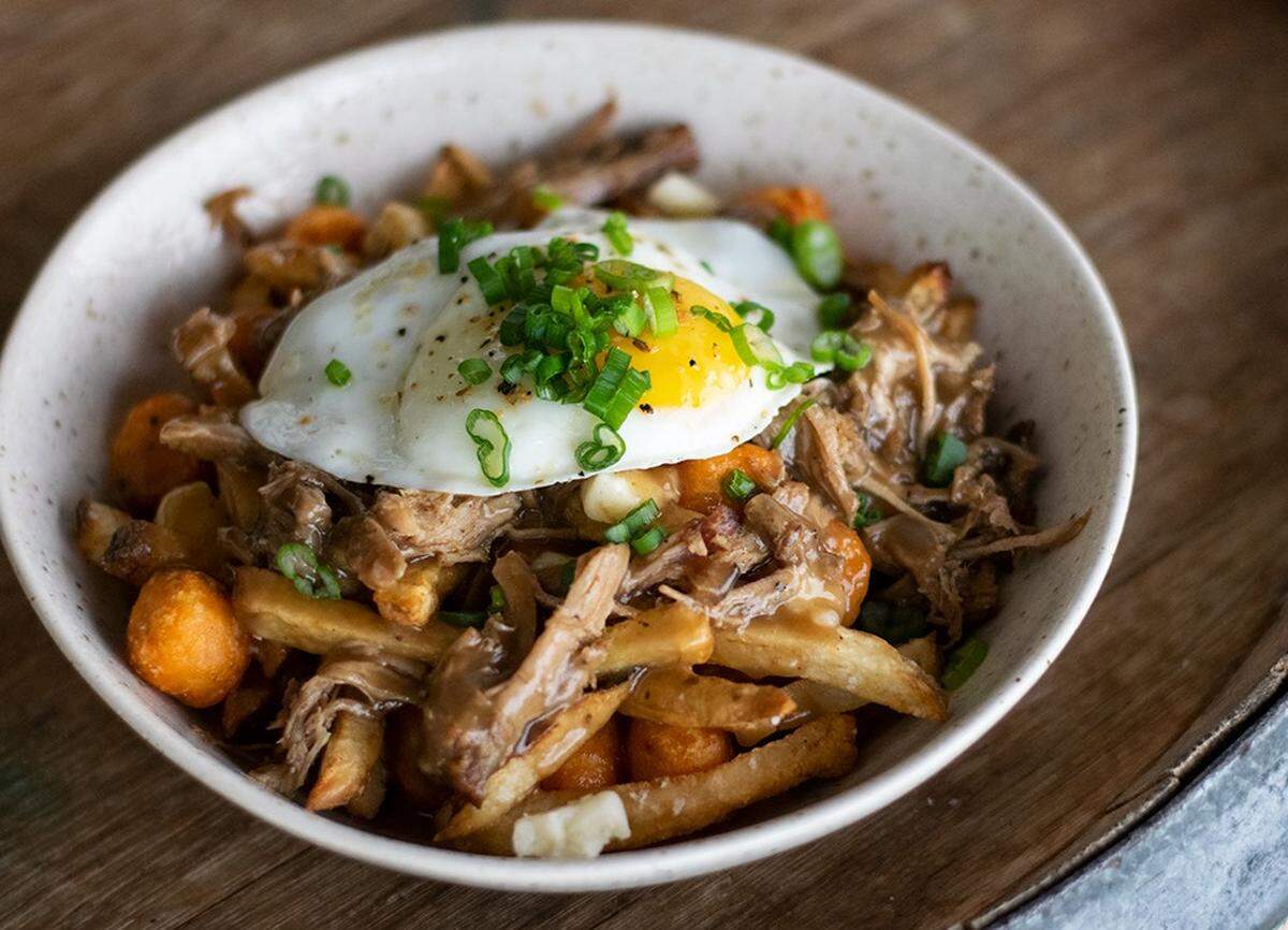 Proof Gatropub on Columbia Center Boulevard in Kennewick features Proof Poutine - waffle fries, white cheddar cheese curds, sweet potato tots, parmesan, smoked pork, peppercorn gravy, sunny-side-up egg, chives and green onions.